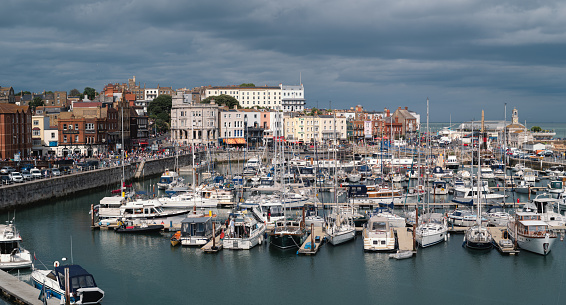 Ramsgate, England - July 31 2022 Panoramic image of the historic Royal Harbour on a cloudy summer day. The town was celebrating its carnival day. image of the historic Royal Harbour on a cloudy summer day. The town was celebrating its carnival day.