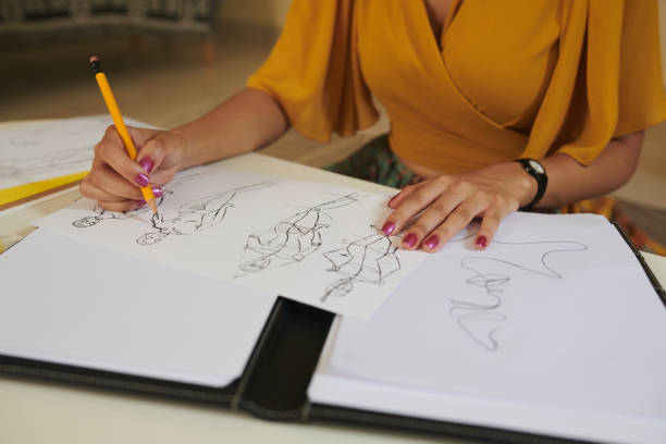 Closeup image of talented designer drawing fashion sketches