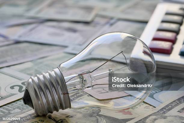 Incandescent Lamp On The Background Of Banknotes The Concept Of The Need To Save Energy Selective Focus Stock Photo - Download Image Now