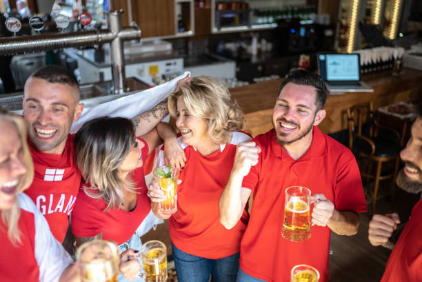 istock Friends celebrating English team winning in a bar 1412532721