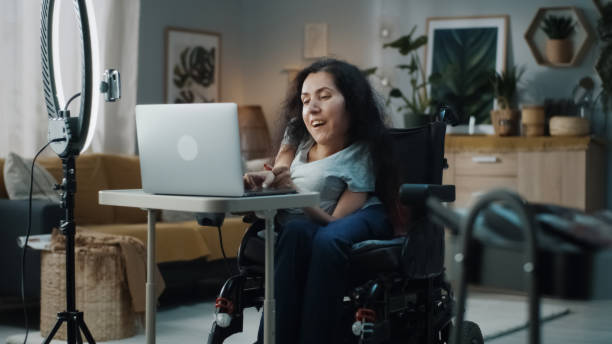 woman with a disability recording a video for blog - motorized wheelchair audio imagens e fotografias de stock
