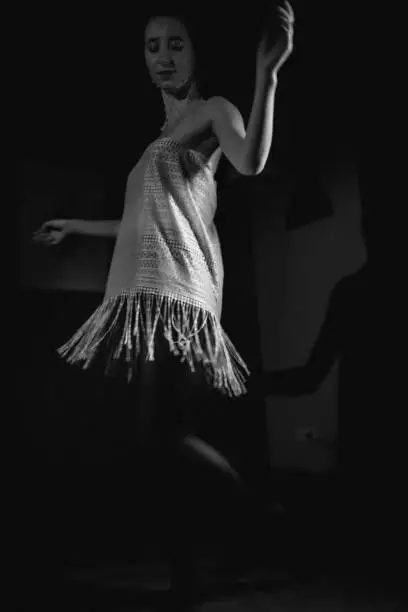 Photo of Girl in a dress posing in a dark room, retro.
