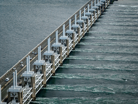 The Eastern Scheldt storm surge barrier known locally as Oosterscheldekering is a floodwater storm protection barrier, shielding the Netherlands from storm surges by closing gates and restricting water flow, holding back the sea water in the event of rising sea levels.
