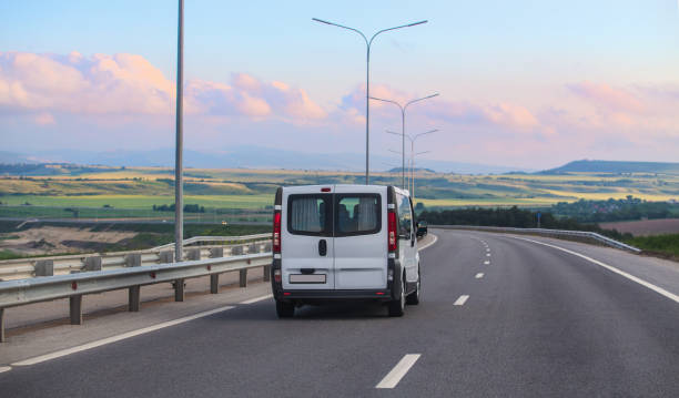 istock Minibus Moves along the Country Highway 1412534217