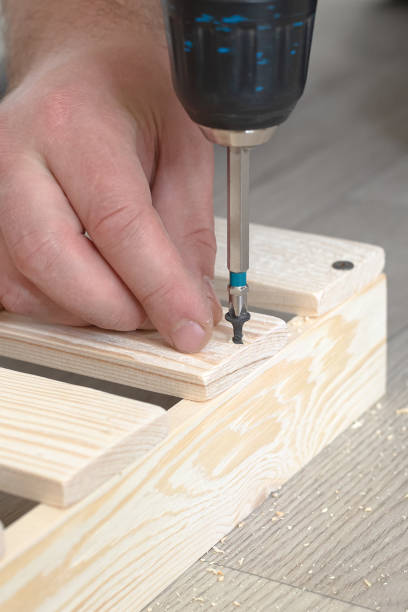 istock Wooden slats and working tools. Carpentry work. The self-tapping screw is screwed into the wooden plank 1412535573