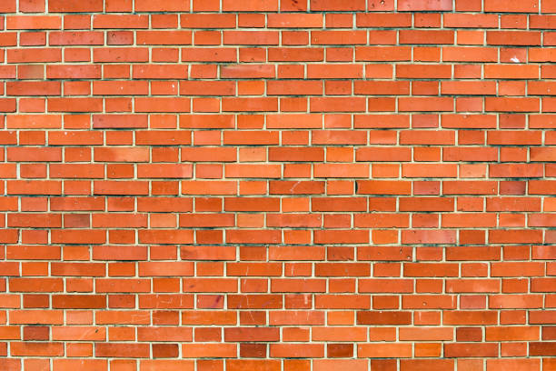 Red brick wall background. Horizontal shot of brickwork pattern as textured graphic design element. Urban facade detail.
