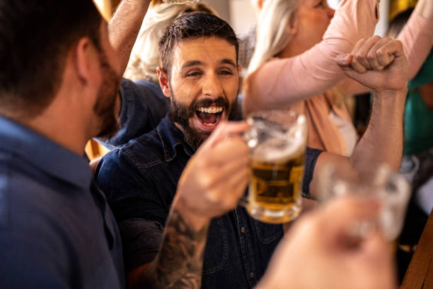 istock Happy friends watching a match and celebrating in a bar 1412537949