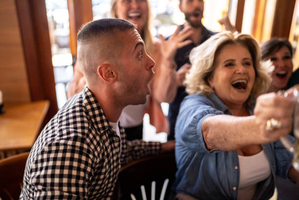 istock Happy friends watching a match and celebrating in a bar 1412538022