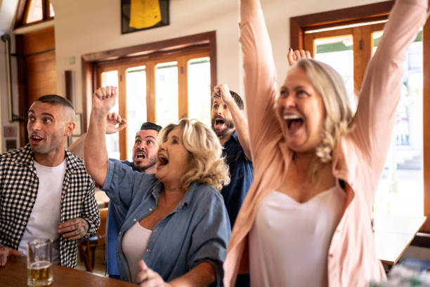 istock Friends celebrating while watching a match in a bar 1412538087