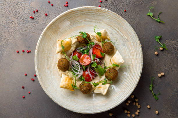 istock hummus with falafel and vegetables on plate on brown table top view 1412538263