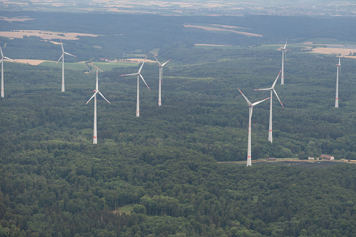 Moeckmuehl, Wurttemberg, Germany, July 11, 2022 Wind energy stations in a green forest seen from a small plane