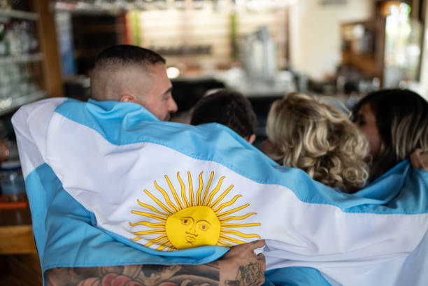 vue arrière des fans de l’équipe argentine regardant un match dans un bar avec drapeau argentin - argentinian ethnicity photos et images de collection