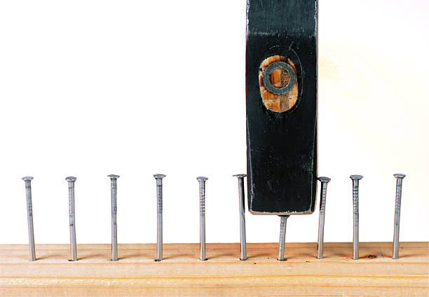istock Hammering a nail into wooden plank. 141254353