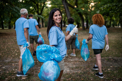 Group of volunteers picking up trash and plastic in the nature