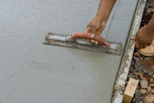 istock A worker is working on a new sidewalk that has just been poured on wet concrete while holding a steel trowel 1412545490