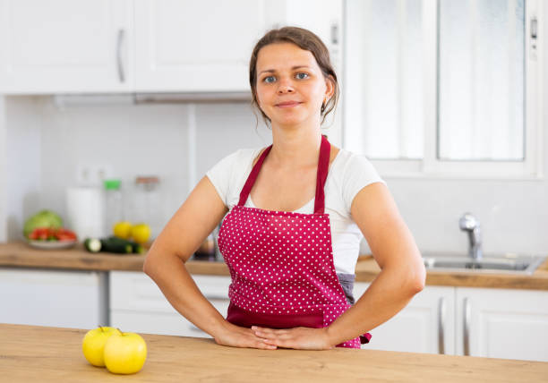 istock Young woman in apron posing in kitchen 1412546674