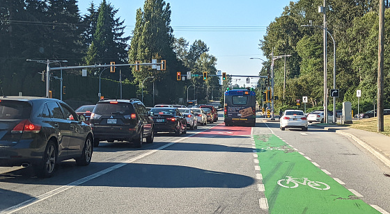 Surrey, Canada - July 30, 2022: Traffic heads north on King George Boulevard at 88th Avenue in the Newton neighbourhood. A red bus lane and green bicycle lane lead to Surrey City Centre.