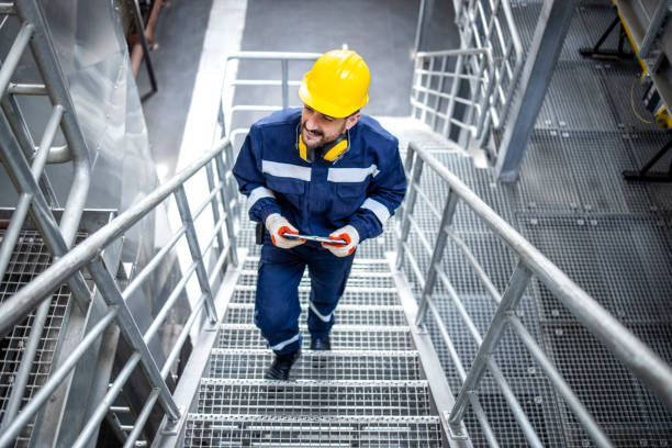 istock Factory worker or engineer in safety work wear walking through large production plant. 1412547590