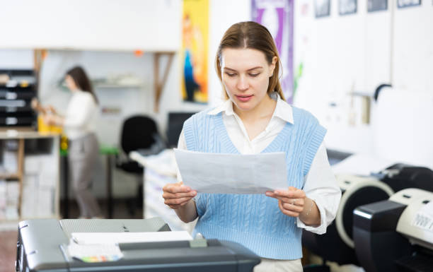 istock Printing office wokrer looking at paper 1412547688