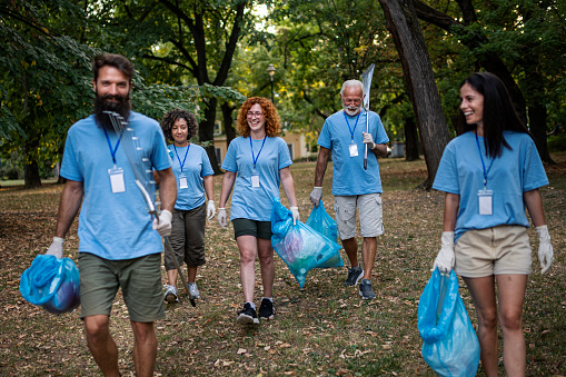 Group of volunteers leaving after cleaning in public park together