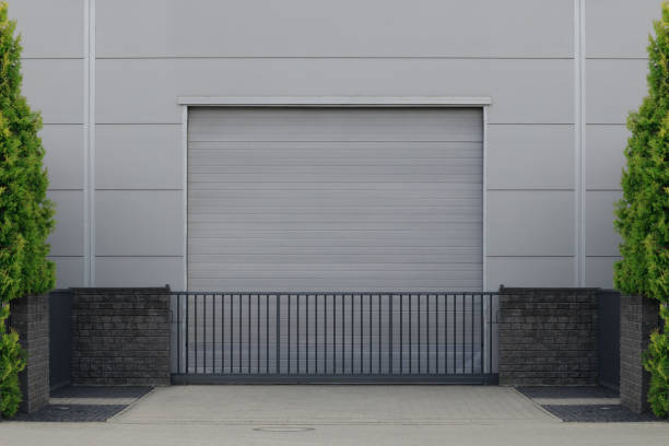 istock Gate or roller shutter with application to factory, warehouse or hangar. Outside, trees on the sides 1412551739