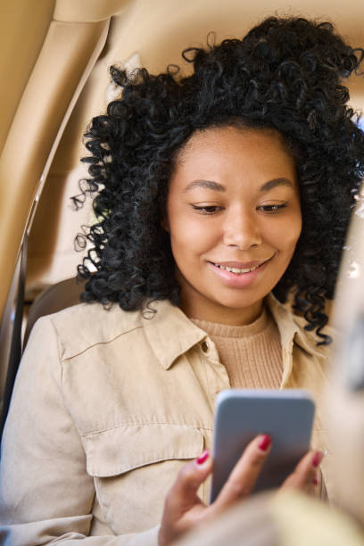istock Curly female looking at the phone with a smile 1412552445