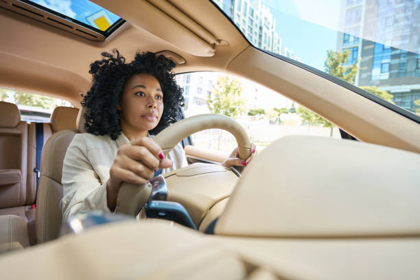 istock Pretty mixed race woman driving a car 1412552482
