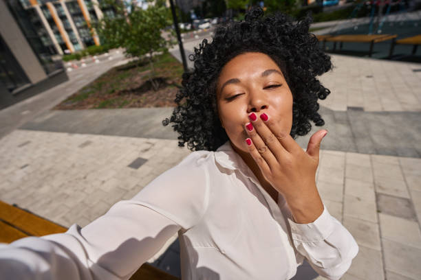 mujer multirracial envía un beso aéreo a la cámara - kissing blowing a kiss blowing women fotografías e imágenes de stock