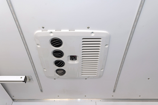 Speaker in the ceiling above the train door, close-up
