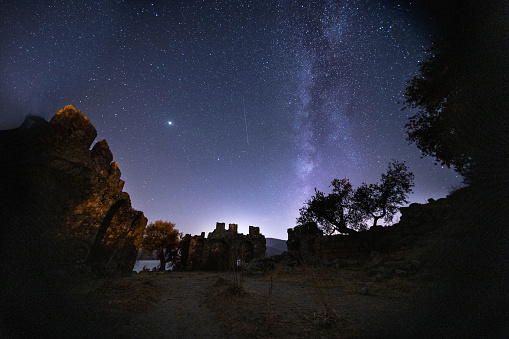 night view of the castle. A view of the stars of the Milky Way with a mountain top in the foreground. Night sky nature summer landscape. Perseid Meteor Shower observation