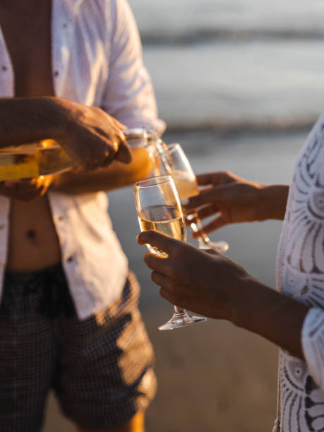 istock honeymoon couple drinking champagne on tropical beach 1412557396