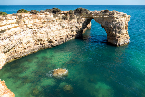 Natural Arch of Albandeira during low tide. Landmark in Lagoa, Algarve, Portugal.