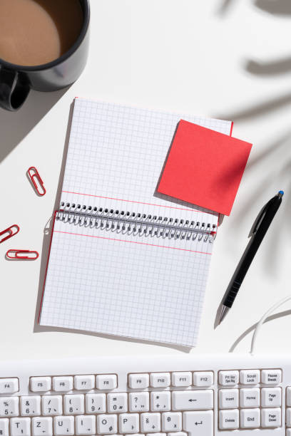 istock Notebook With Important Messages On Both Sides On Desk With Coffee, Pen, Paperclips, Keyboard And Memos. Crutial Information On Pad On Table With Cup And Pencil. 1412562799