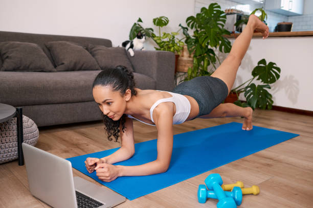 istock A young multi-ethnic woman does a raised leg push up in her home 1412567471