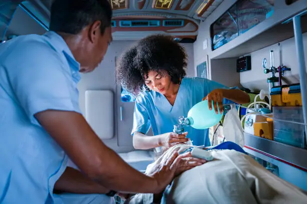 Photo of Team of paramedic is helping the senior patient who is stop breathing from car crash by using respirator for heart attack and street accident concept