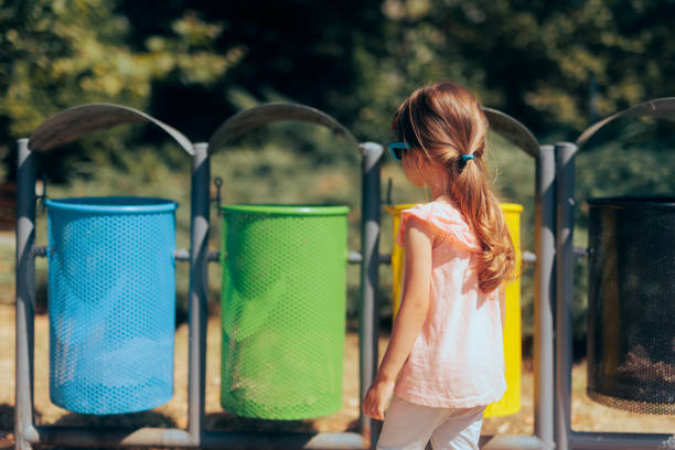 istock Little Girl Learning to Use Recycle Bins for Garbage Disposal 1412569854