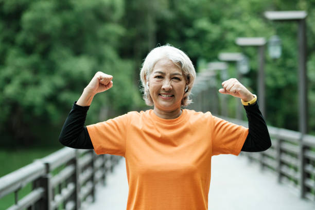 istock Athletic Senior woman stretching arms in park. 1412569984