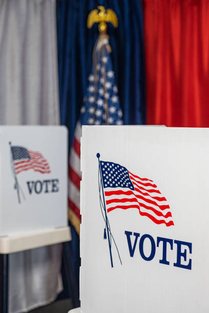 istock Two empty voting booths with bunting and American flag 1412572210