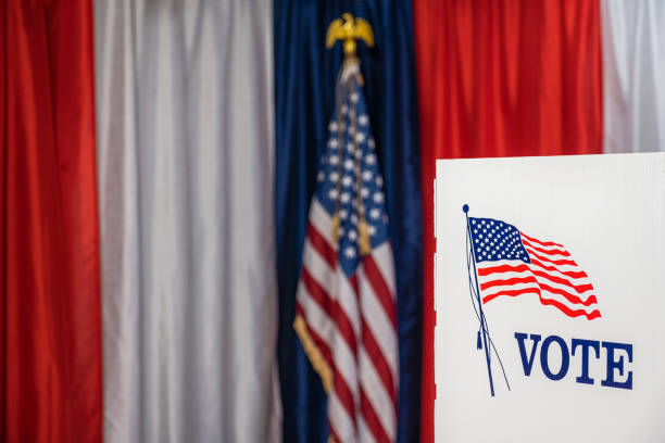 One empty voting booths with red, white and blue bunting and an American flag in the background of this voting precinct.