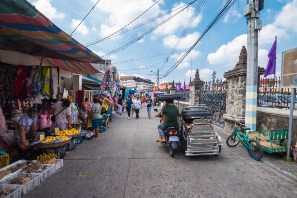 Angeles, Pampanga, Philippines - April 2022: A tricycle passes by the local market scene. Angeles, Pampanga, Philippines - April 2022: A tricycle passes by the local market scene. philippines tricycle stock pictures, royalty-free photos & images