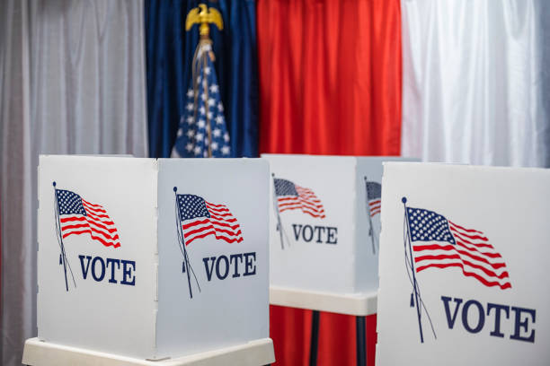 Three empty voting booths with bunting and American flag Three empty voting booths with red, white and blue bunting and an American flag in the background of this voting precinct. midterm election stock pictures, royalty-free photos & images
