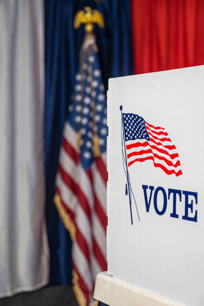 istock One empty voting booths with bunting and American flag 1412572507
