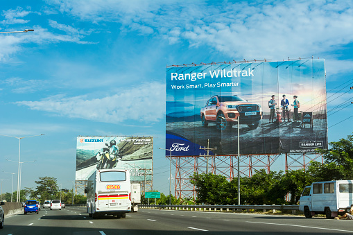 Bocaue, Bulacan, Philippines - April 2022: A bus passes through large billboard ads on the northbound lane of NLEX.