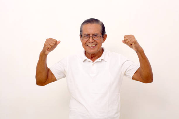 istock Happy asian old man standing while showing strong gesture. Isolated on white background 1412573551