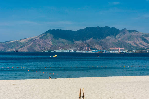 montagne panoramiche e un cantiere navale visto dalla spiaggia di barretto, una popolare località turistica vicino a subic a olongapo, zambales. - subic foto e immagini stock