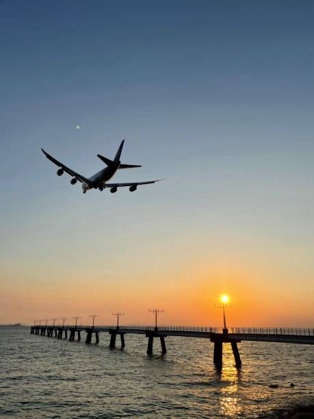 vue côtière d’un avion survolant la mer sous un ciel vibrant au coucher du soleil, hong kong - hong kong sea sky cloud photos et images de collection