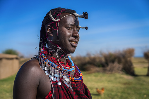 Portrait of Maasai mara man with traditional colorful necklace and clothing at Maasai Mara tribe village, Safari travel destination near Maasai Mara National Reserve, Kenya