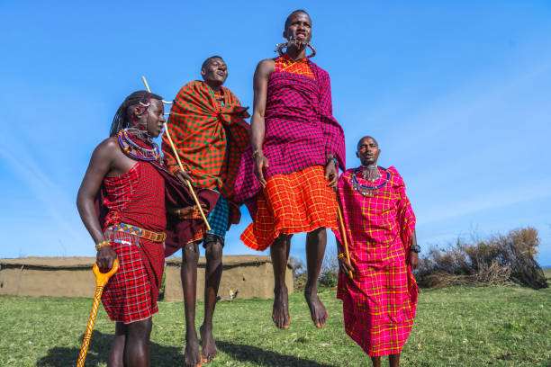 Maasai Mara man showing traditional Maasai jumping dance Maasai Mara man in traditional colorful clothing showing traditional Maasai jumping dance at Maasai Mara tribe village famous Safari travel destination near Maasai Mara National Reserve Kenya masai stock pictures, royalty-free photos & images