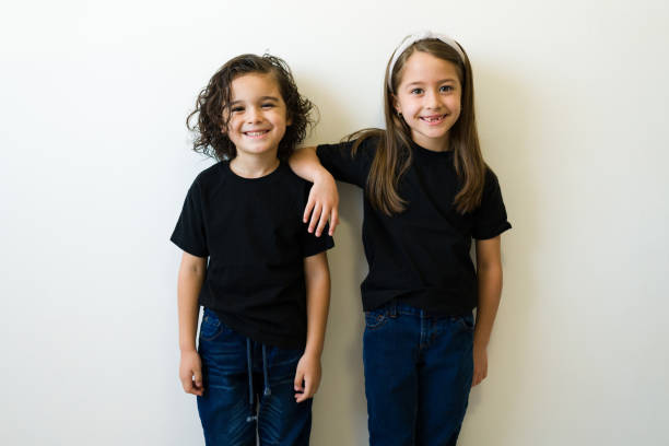 istock Cheerful kids posing with their design prints mockup t-shirts 1412581366