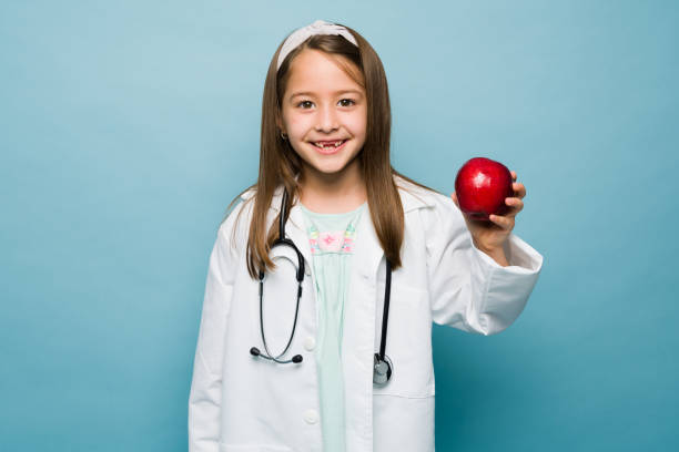 istock Happy girl dressed with a lab coat dressed as a nutritionist 1412583397